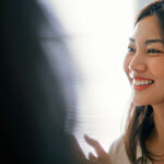 Smiling woman with long dark hair in a modern office.