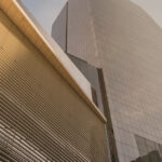 Low-angle view of modern skyscrapers in Latin America with louvered and glass facades under a clear sky.