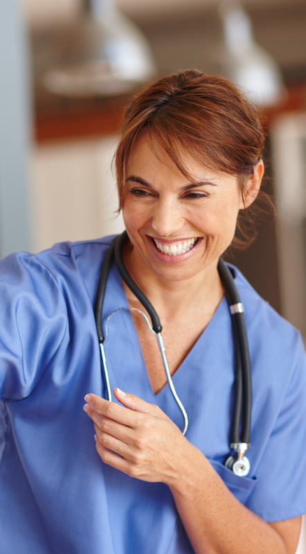 Smiling woman in blue scrubs with a stethoscope around her neck.