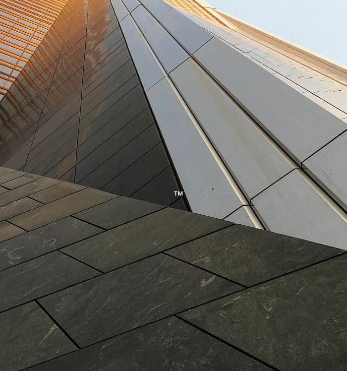 Close-up of a modern building facade with geometric metal and glass panels.