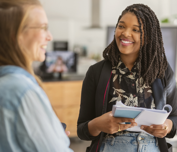 A woman holding a catalog smiles at a customer