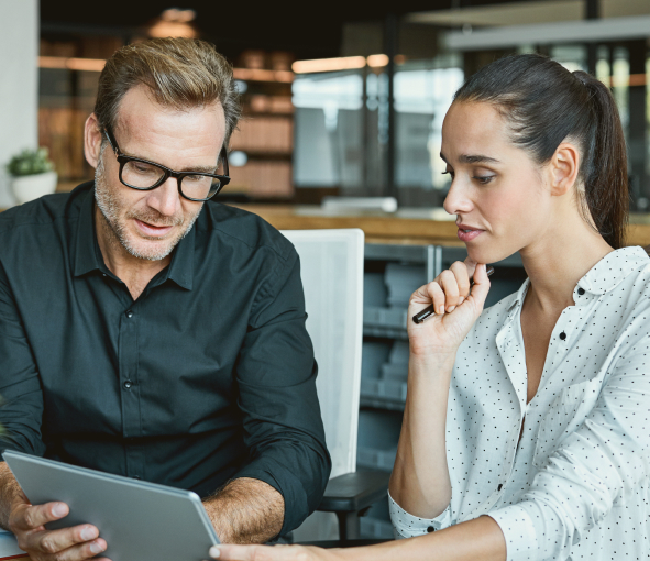 A man and a woman working on a tablet