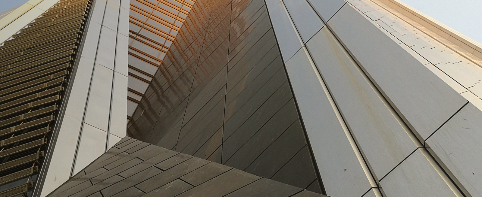 Close-up of a modern building facade with geometric metal and glass panels.