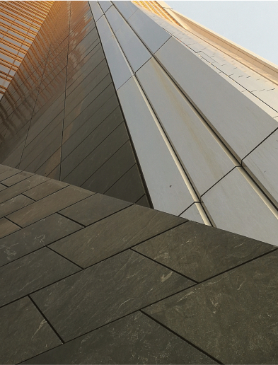 Close-up of a modern building facade with geometric metal and glass panels.