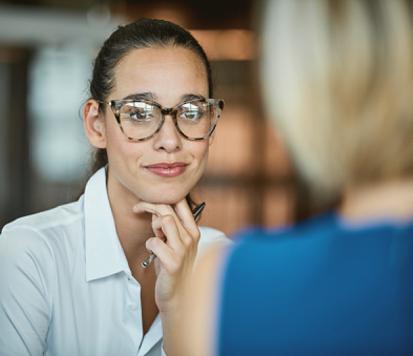 A woman wearing glasses listening thoughtfully