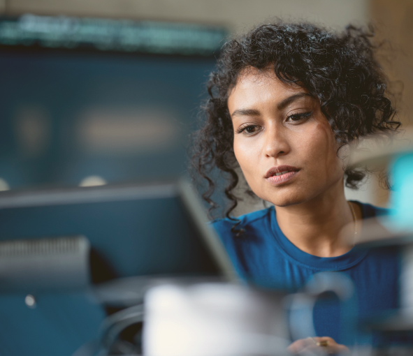 A woman works intently at a desk