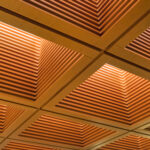 Wooden ceiling with recessed squares and glowing lights.