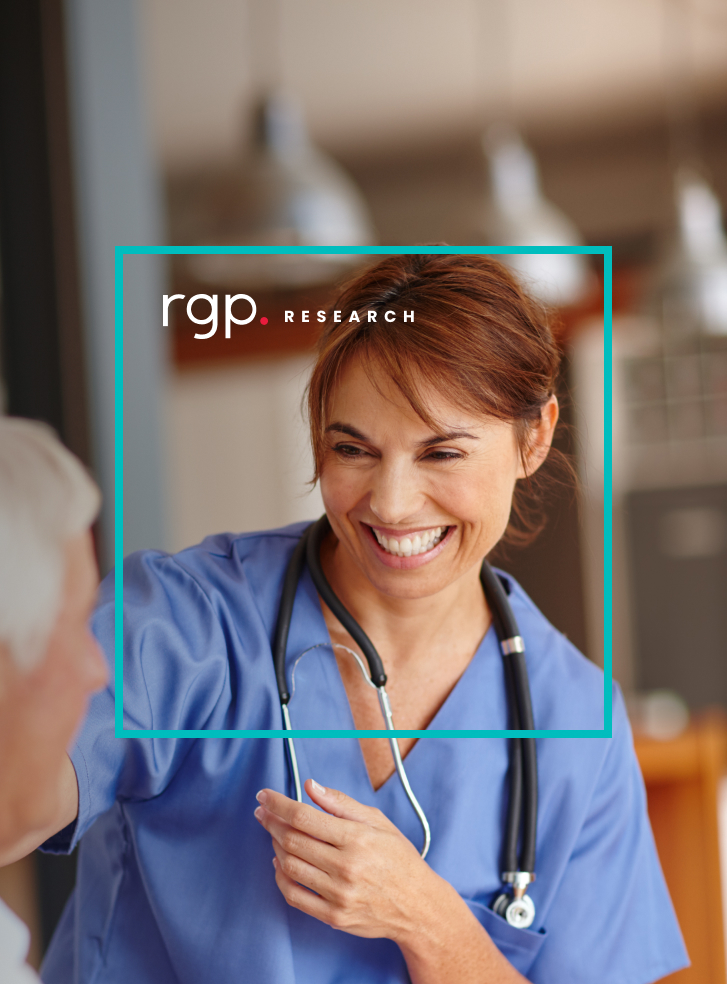 A healthcare professional wearing scrubs laughs with a patient