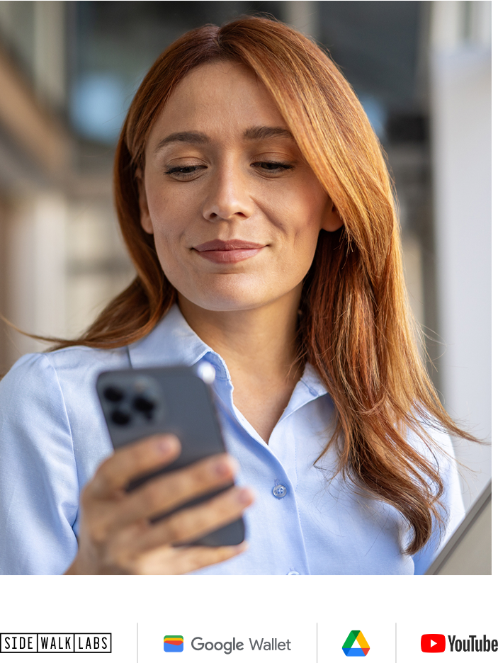 Woman in light blue button up shirt and looking at phone
