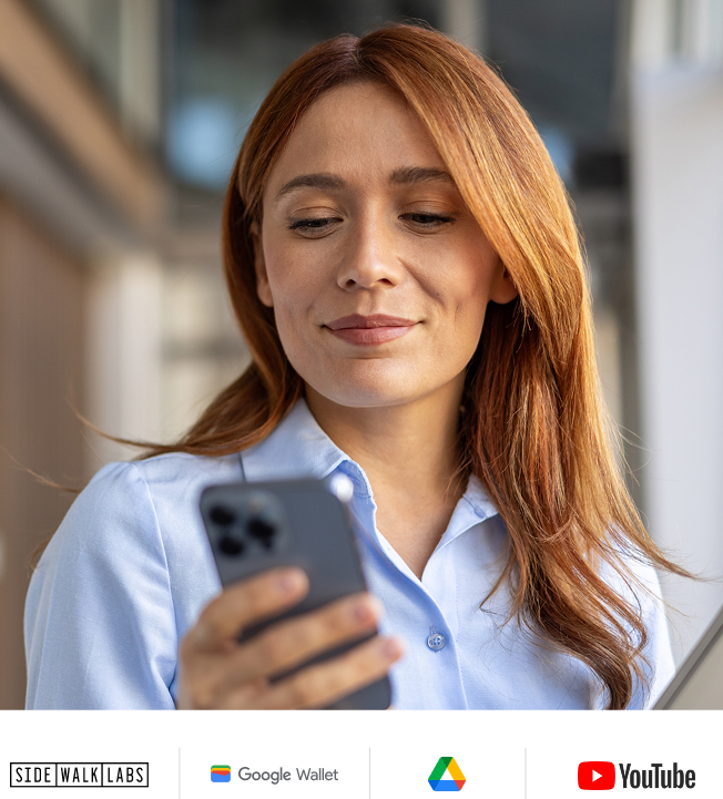 Woman in light blue button up shirt and looking at phone