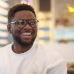 A man in glasses with a beard looks to the right with a smile