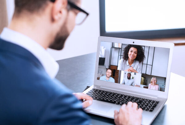 Man on a video call on a laptop with group of people 